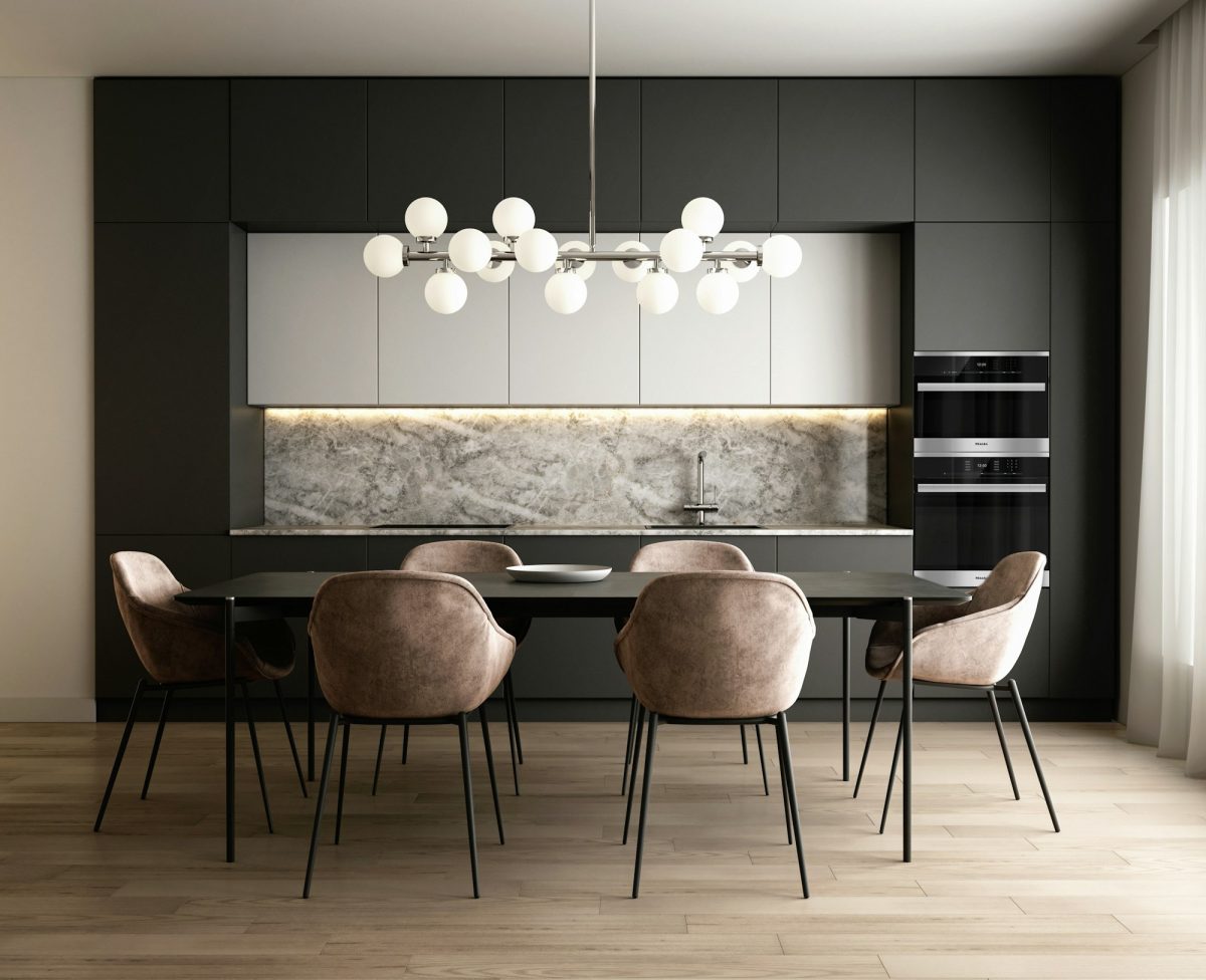 Dark contemporary kitchen and dining area with statement lighting